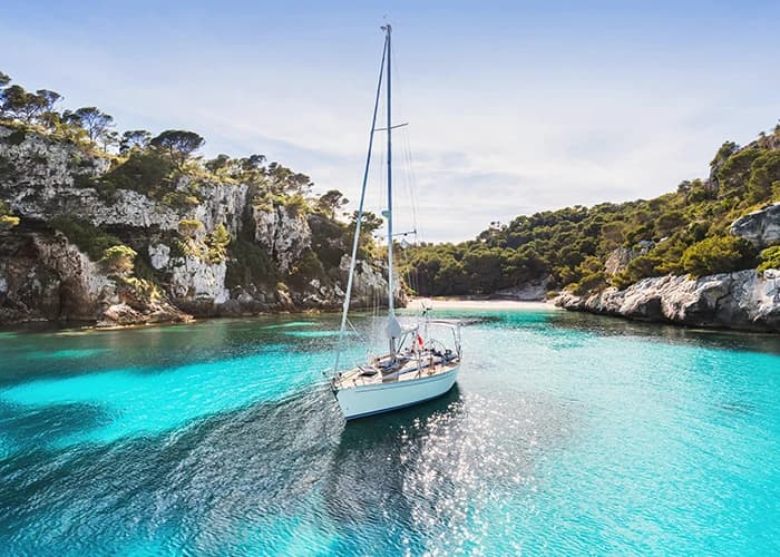 Beach with sailing boat and yacht