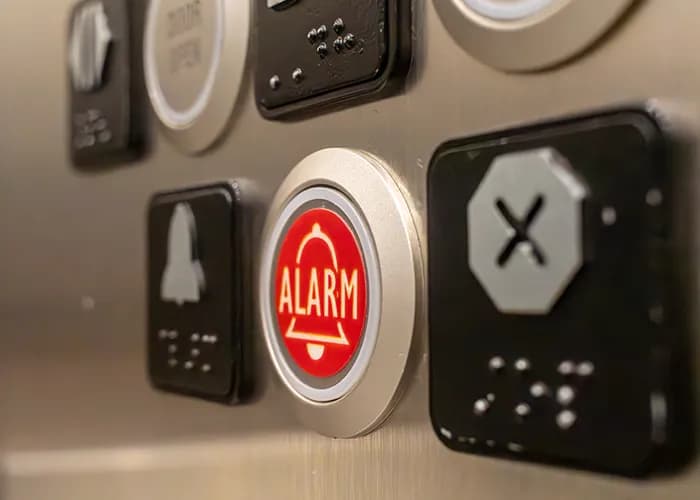 close-up of red alarm button on elevator control panel