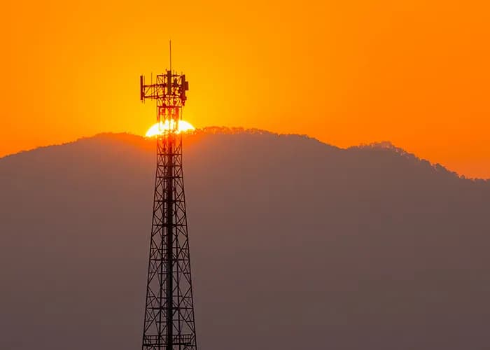 Communications tower in front of sunset