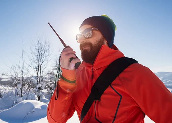 Man using communication device in snowy landscape